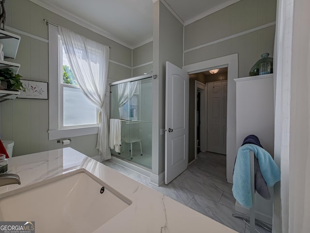 bathroom with marble finish floor, crown molding, and a stall shower