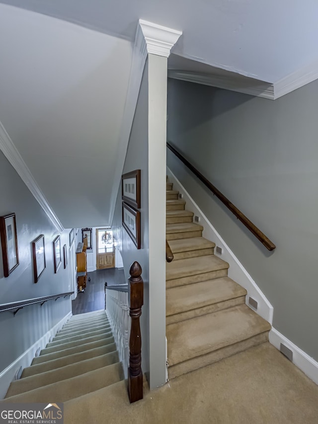 stairs with baseboards, crown molding, and carpet floors