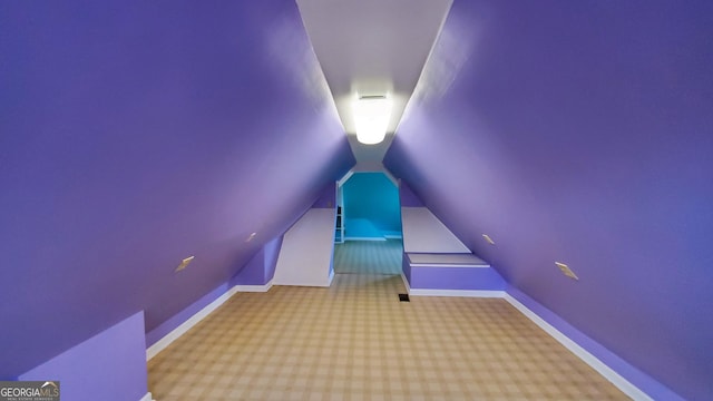 additional living space with baseboards, vaulted ceiling, and carpet flooring