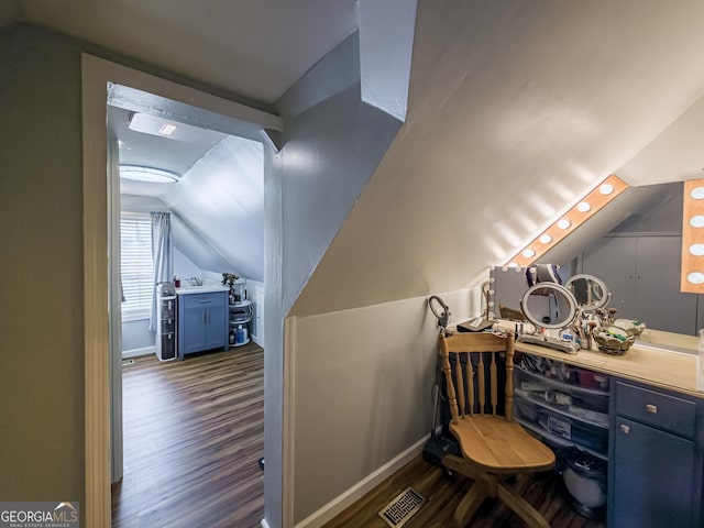 office area with baseboards, lofted ceiling, visible vents, and dark wood-style floors