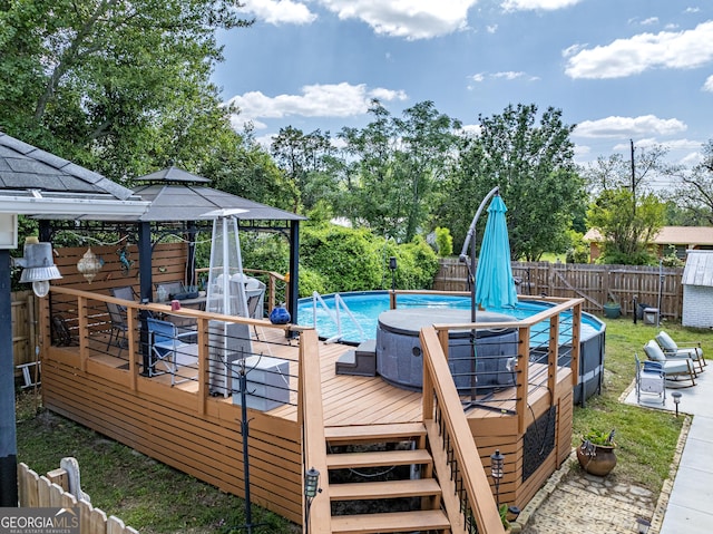 view of swimming pool with a fenced backyard, a fenced in pool, a gazebo, and a deck