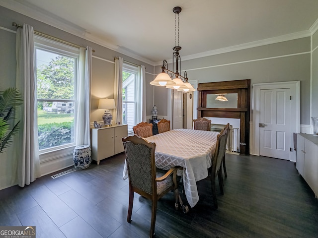 dining area featuring crown molding, visible vents, a chandelier, and dark wood-style flooring