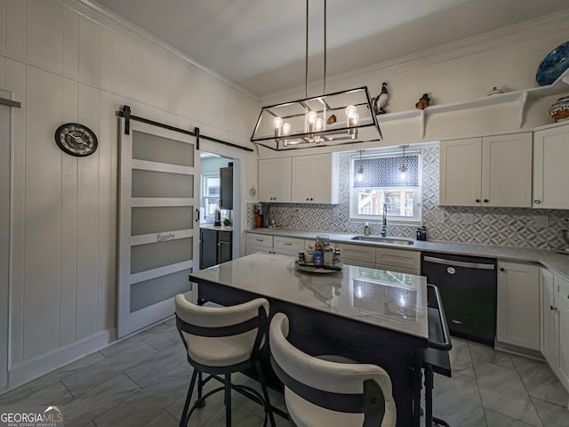kitchen with backsplash, dishwasher, a sink, crown molding, and a kitchen bar