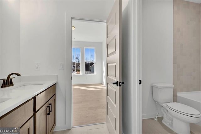 bathroom featuring a bathtub, toilet, baseboards, walk in shower, and vanity