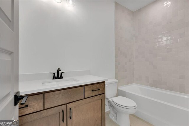 bathroom with toilet, vanity, and tile patterned floors