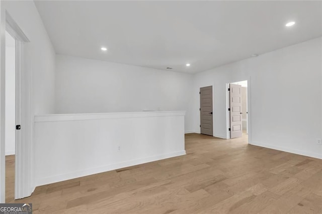 empty room with recessed lighting, light wood finished floors, and baseboards