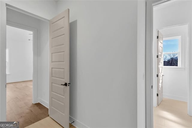 corridor featuring baseboards and light wood-style floors