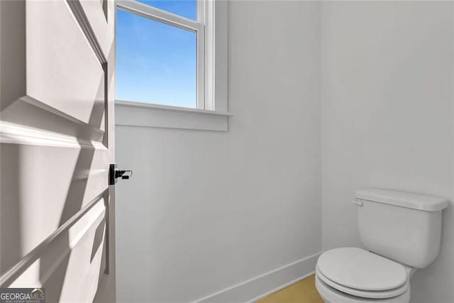 bathroom featuring toilet and baseboards