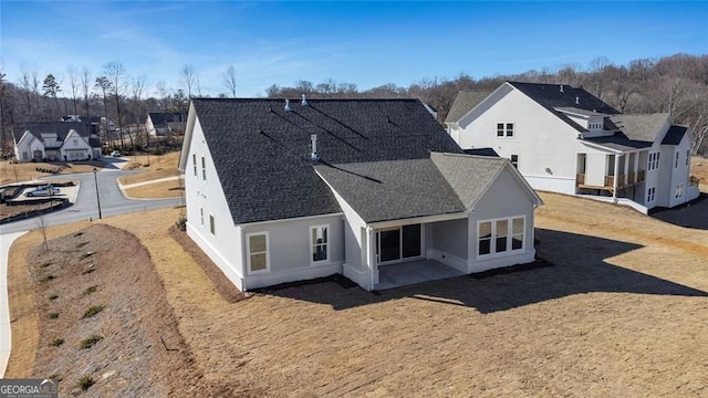 rear view of property with roof with shingles and a residential view