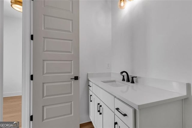 bathroom featuring baseboards, wood finished floors, and vanity
