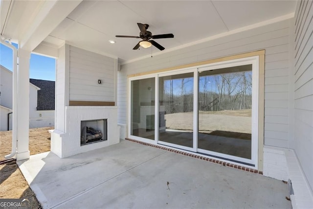 view of patio with exterior fireplace and ceiling fan