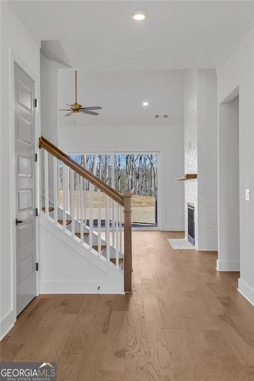 staircase featuring wood finished floors, ceiling fan, baseboards, visible vents, and recessed lighting
