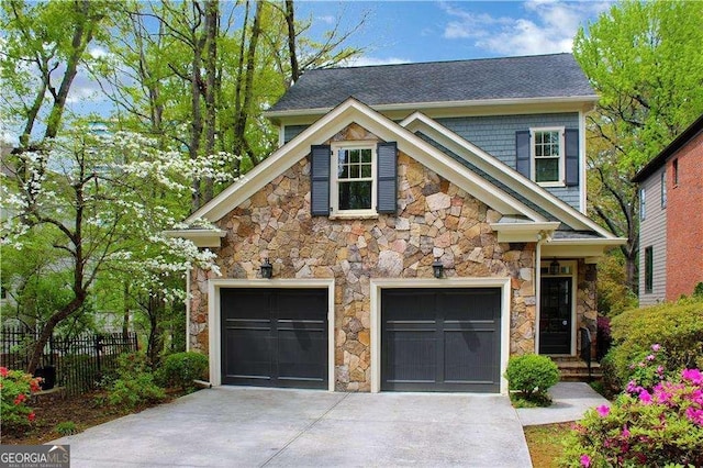 view of front facade featuring stone siding, fence, concrete driveway, and an attached garage