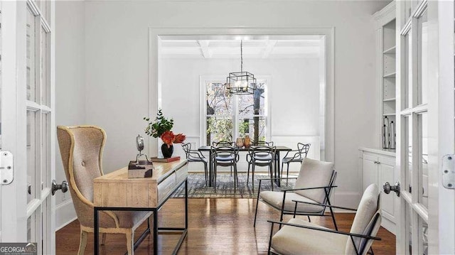 dining space featuring coffered ceiling, wood finished floors, a chandelier, and beam ceiling