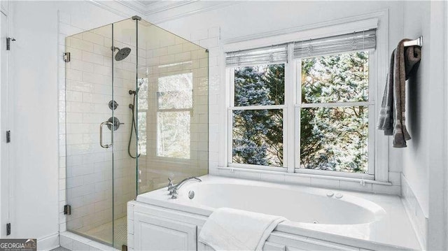full bathroom featuring healthy amount of natural light, a stall shower, and a bath