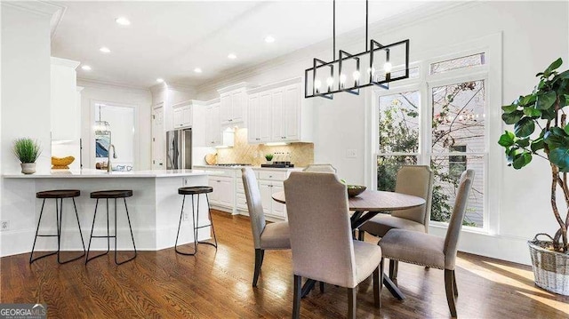dining space featuring ornamental molding, a chandelier, dark wood-style flooring, and recessed lighting