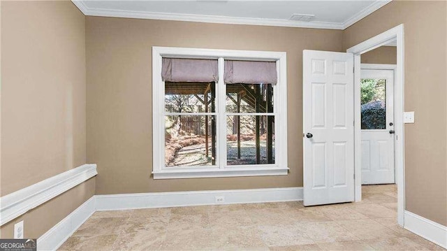spare room with baseboards and crown molding