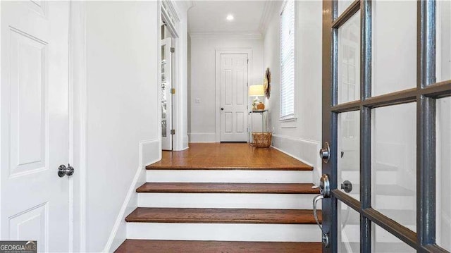 stairway with baseboards and crown molding