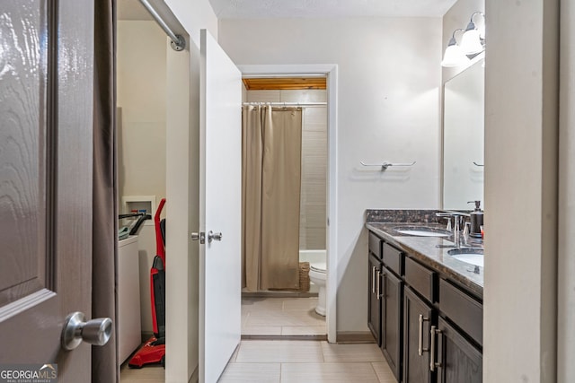 bathroom featuring stacked washer / dryer, toilet, double vanity, and shower / tub combo with curtain