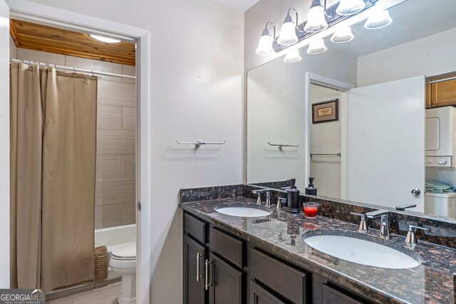laundry area with stacked washing machine and dryer and cabinet space