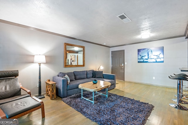 living area featuring wine cooler, wood finished floors, ornamental molding, and baseboards