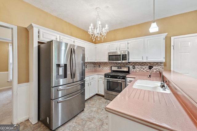 10044 Point View Dr, Jonesboro, GA 30238 - kitchen featuring appliances with stainless steel finishes, a sink, a chandelier, white cabinetry, and tasteful backsplash