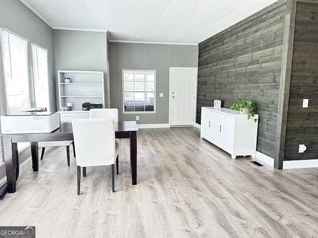 112 Little River Ct, Eatonton, GA 31024 - dining area with light wood-style flooring, wood walls, baseboards, visible vents, and crown molding