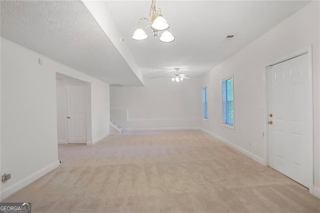 foyer entrance with baseboards, stairs, light colored carpet, and ceiling fan with notable chandelier