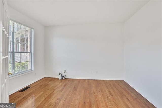 unfurnished room with light wood-style flooring, visible vents, and baseboards