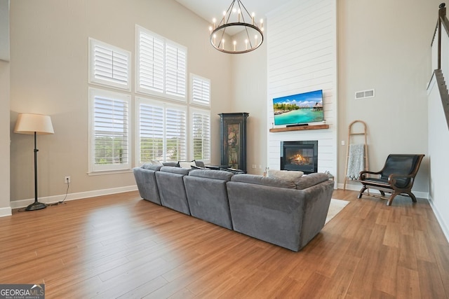 2127 Harmony Dr, Canton, GA 30115 - living area with a high ceiling, a fireplace, baseboards, a chandelier, and light wood-style flooring