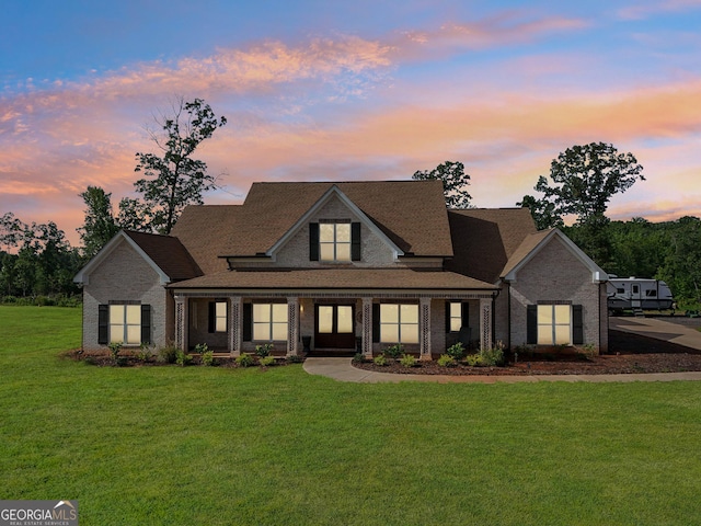 view of front of home with a yard and brick siding