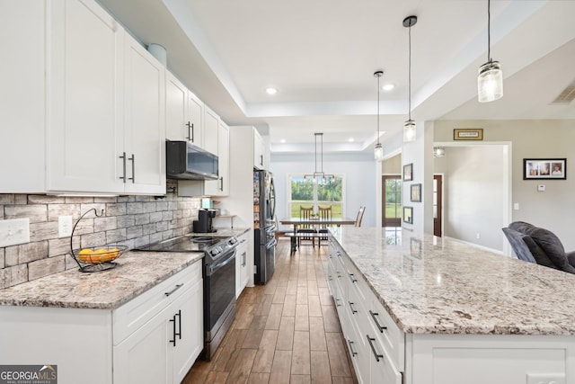 kitchen with dark wood finished floors, freestanding refrigerator, backsplash, a kitchen island, and black range with electric stovetop