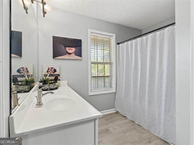 4643 Grand Central Pkwy, Decatur, GA 30035 - full bathroom featuring wood finished floors, a textured ceiling, vanity, and baseboards