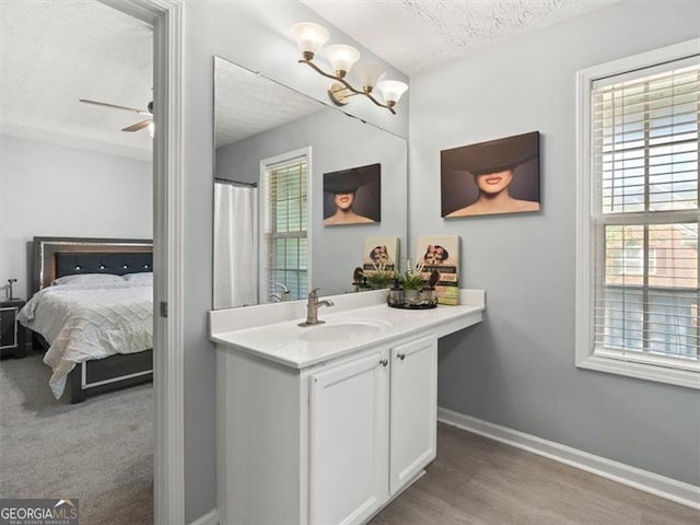 4643 Grand Central Pkwy, Decatur, GA 30035 - ensuite bathroom featuring a textured ceiling, healthy amount of natural light, baseboards, and vanity