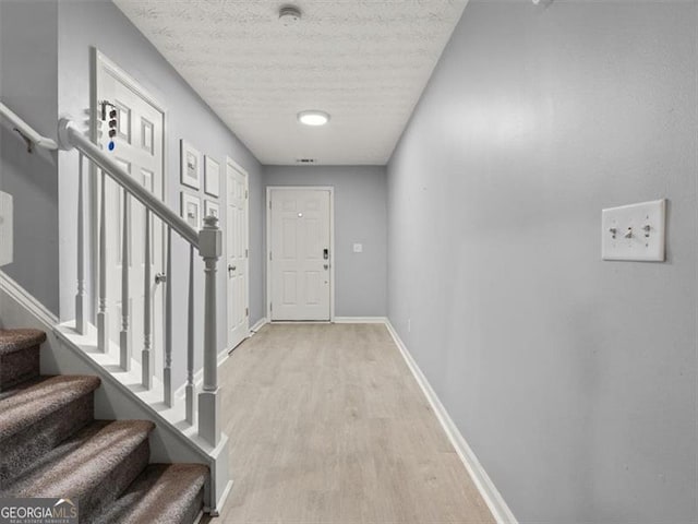 4643 Grand Central Pkwy, Decatur, GA 30035 - entryway featuring stairway, light wood finished floors, baseboards, and a textured ceiling