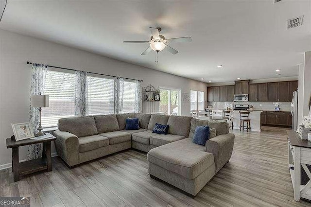 living area with a ceiling fan, light wood-style floors, baseboards, visible vents, and recessed lighting