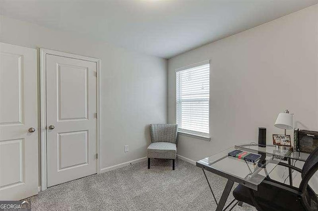 office space featuring baseboards and light colored carpet