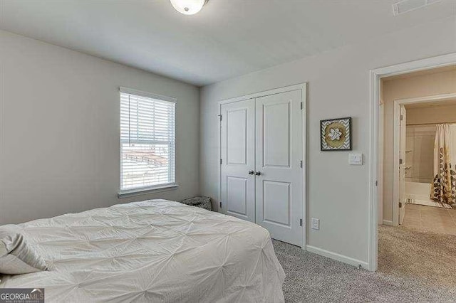 carpeted bedroom featuring a closet and baseboards