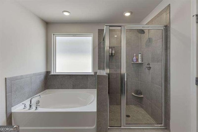 bathroom featuring a bath and a stall shower