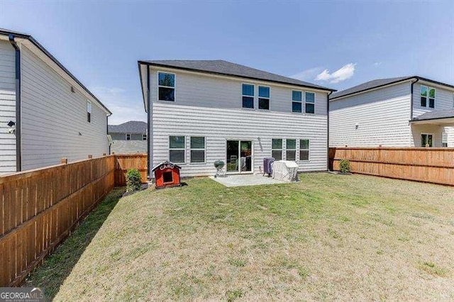 rear view of house with a patio area, a lawn, and a fenced backyard