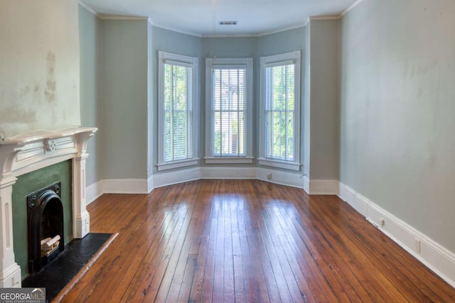 unfurnished living room featuring hardwood / wood-style flooring, baseboards, visible vents, and a fireplace