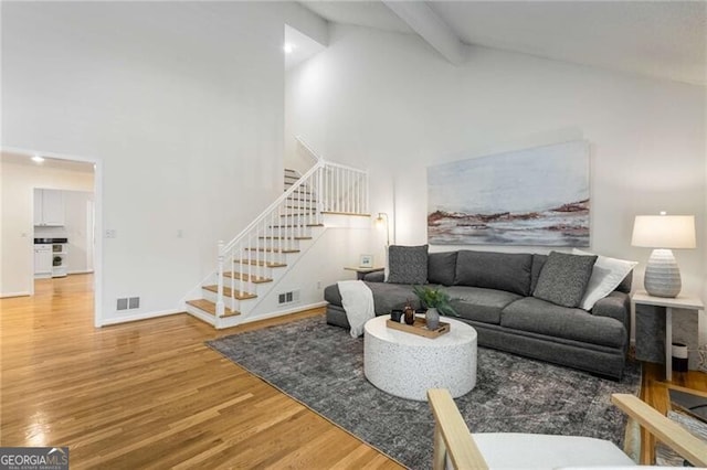 1420 Defoors Dr NW, Atlanta, GA 30318 - living area featuring beam ceiling, visible vents, wood finished floors, stairway, and high vaulted ceiling