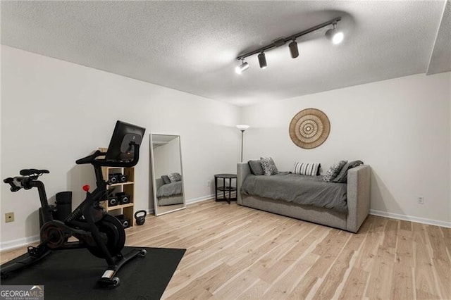 1420 Defoors Dr NW, Atlanta, GA 30318 - workout area featuring track lighting, baseboards, a textured ceiling, and light wood-style floors