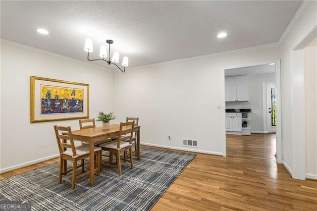 1420 Defoors Dr NW, Atlanta, GA 30318 - dining room with wood finished floors, visible vents, ornamental molding, and an inviting chandelier