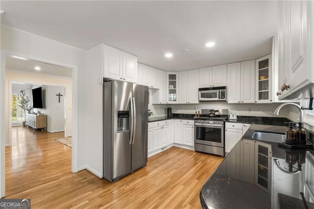 1420 Defoors Dr NW, Atlanta, GA 30318 - kitchen featuring dark countertops, light wood-type flooring, stainless steel appliances, and a sink