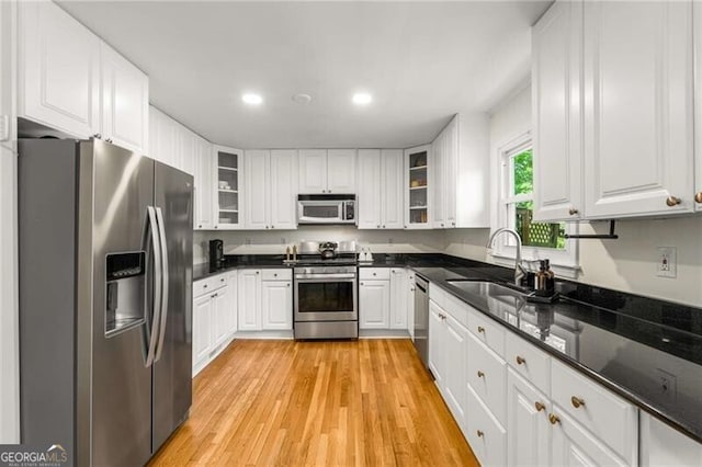 1420 Defoors Dr NW, Atlanta, GA 30318 - kitchen featuring white cabinets, stainless steel appliances, a sink, light wood-type flooring, and glass insert cabinets