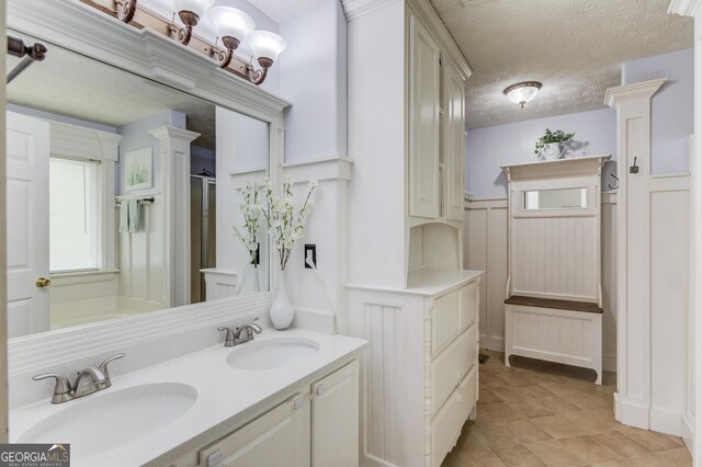 3095 Willow Park Dr, Dacula, GA 30019 - full bath with wainscoting, a sink, double vanity, and a decorative wall