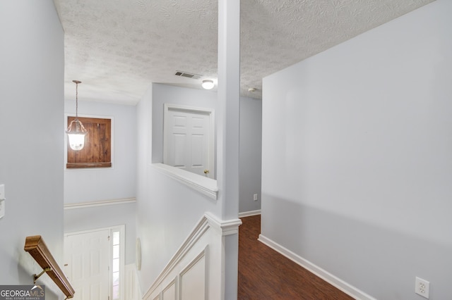 3095 Willow Park Dr, Dacula, GA 30019 - hallway featuring a textured ceiling, wood finished floors, visible vents, and baseboards