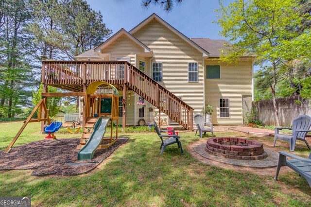 3095 Willow Park Dr, Dacula, GA 30019 - back of property with a playground, fence, a wooden deck, a lawn, and a fire pit