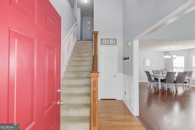 3095 Willow Park Dr, Dacula, GA 30019 - foyer featuring wainscoting, wood finished floors, an inviting chandelier, and stairway